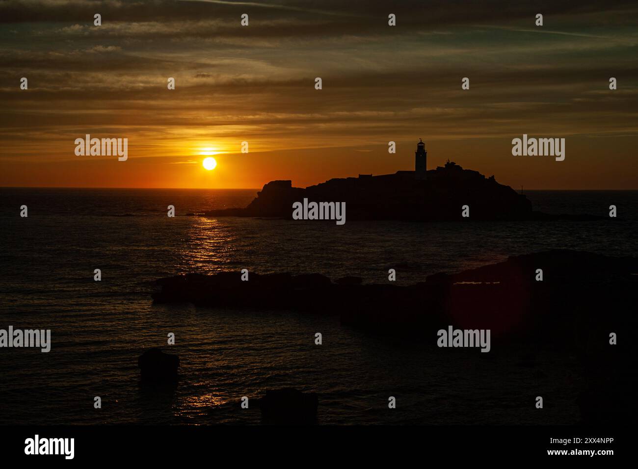 Coucher de soleil sur le phare de Godrevy vu du sommet de la falaise près de la côte de Gwithian, Cornwall, Royaume-Uni Banque D'Images