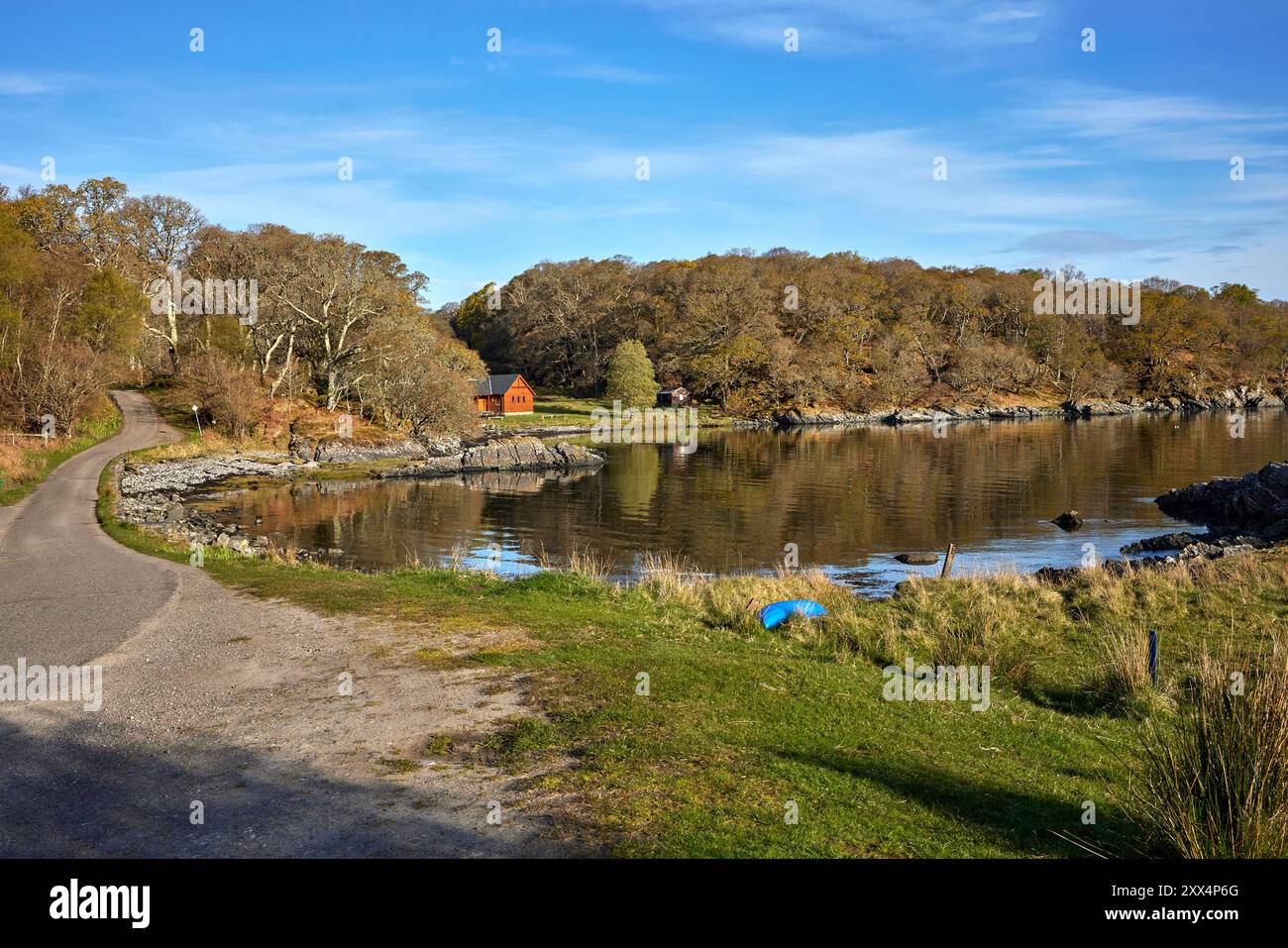 À marée haute, une vue calme et réfléchissante sur la baie Glenuig vers la salle communautaire. Glenuig, Écosse Banque D'Images