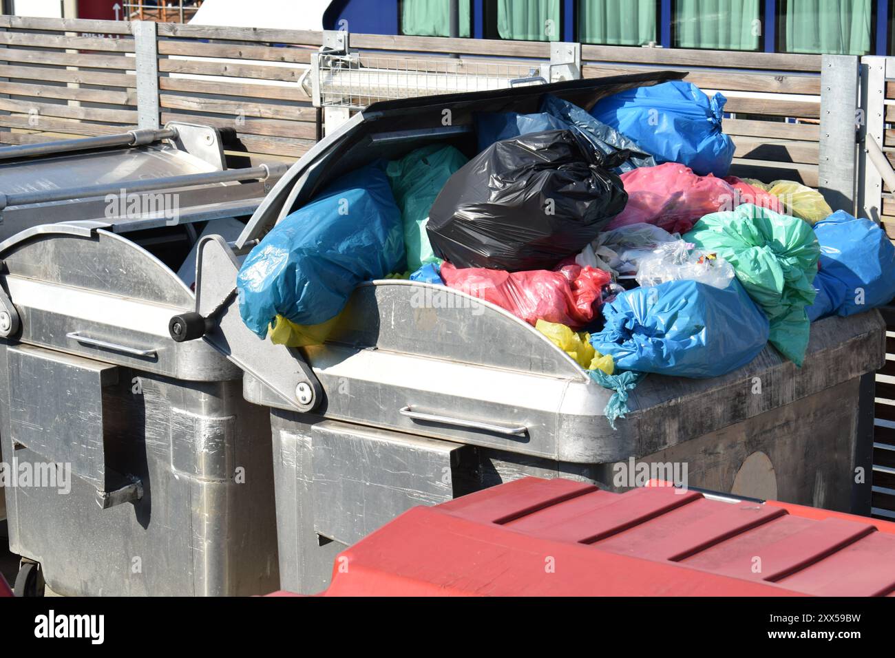 Sacs poubelles en plastique dans un conteneur plein en métal Banque D'Images