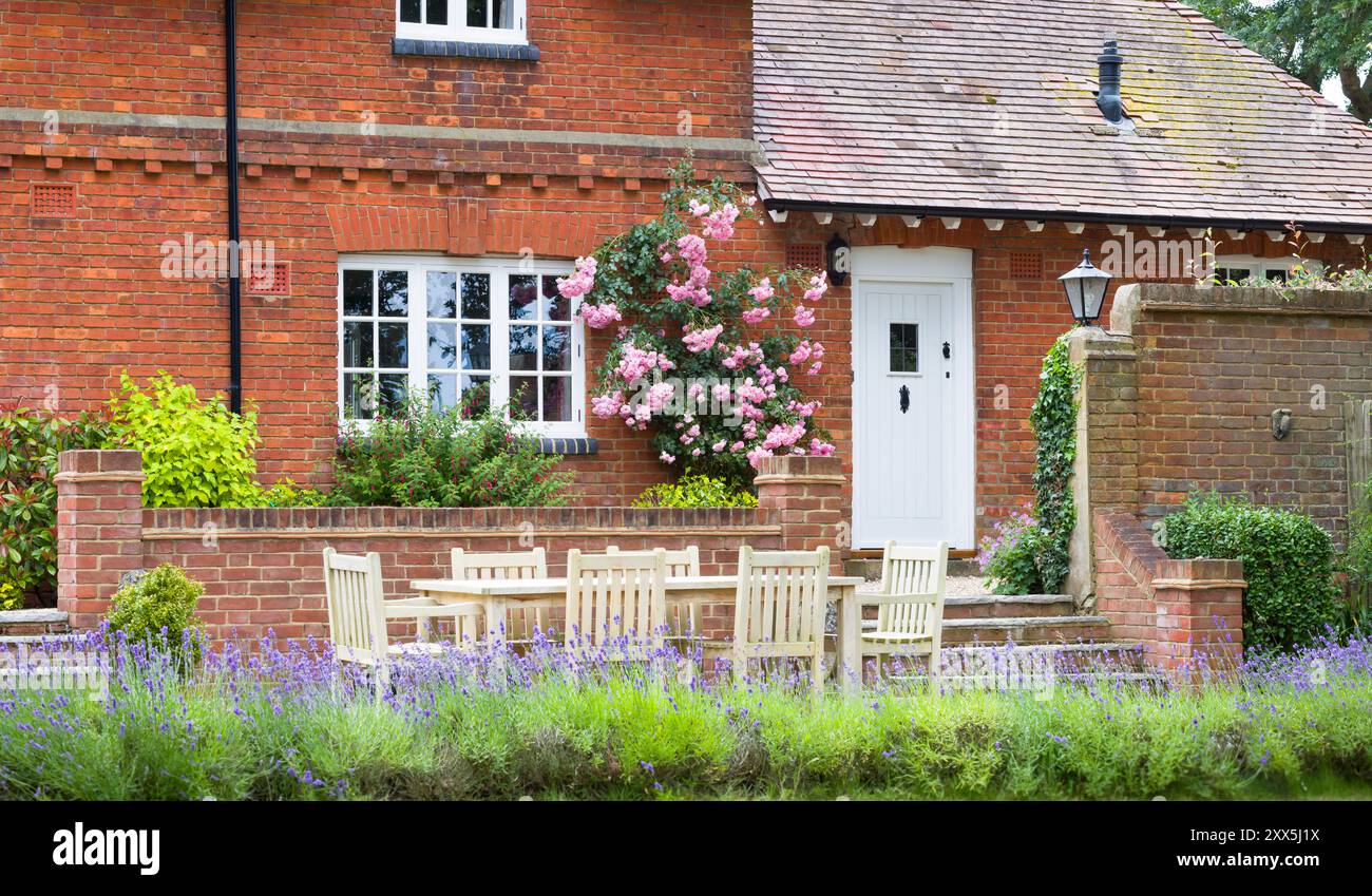 Extérieur de la grande maison britannique. Maison de campagne et jardin avec meubles de patio en bois Banque D'Images