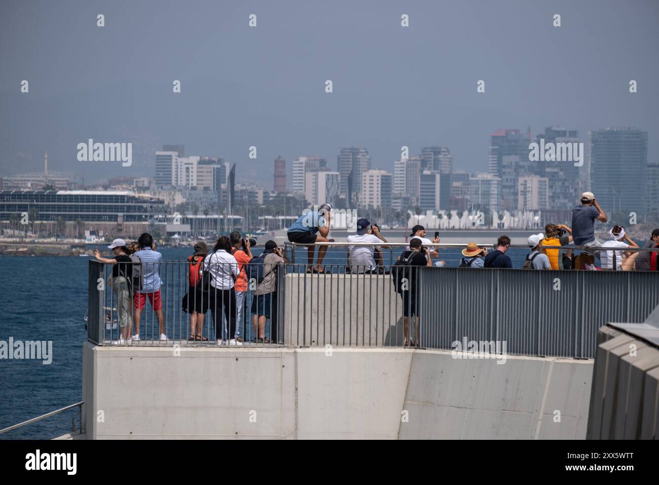 Barcelone, Espagne. 22 août 2024. Un groupe de personnes est vu sur le brise-lames côtier après le premier tour préliminaire des courses de voile de la Coupe de l'America. La Louis Vuitton Preliminary Regatta 2024 America's Cup a entamé les premières courses préliminaires ce matin. Visiteurs, touristes et résidents ont pu profiter gratuitement de la première course de la compétition depuis les points de vue sur le front de mer et sur de grands écrans situés dans les zones de fans. (Photo Paco Freire/SOPA images/SIPA USA) crédit : SIPA USA/Alamy Live News Banque D'Images