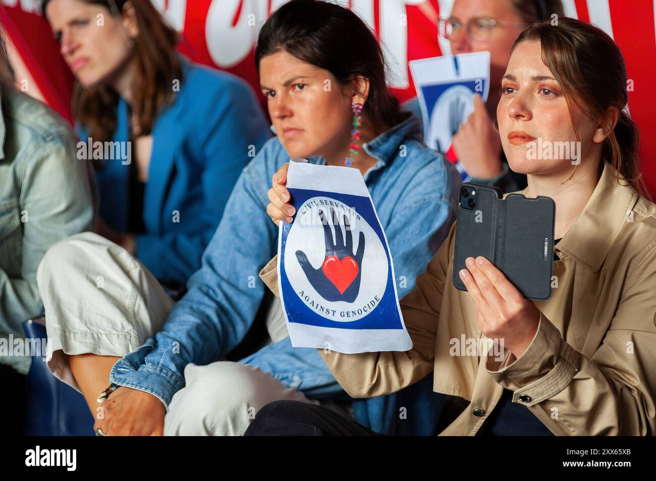 Une manifestante tient une pancarte exprimant son opinion pendant la manifestation. Clival Servants, médecins et magistrats de la Haye ont organisé une manifestation pro-palestinienne à l'heure du déjeuner près de l'entrée du ministère des Affaires étrangères. Depuis le 7 octobre, Israël a lancé sa campagne militaire dans la bande de Gaza, tuant plus de 40,223 Palestiniens, pour la plupart des femmes et des enfants, et plus de 16 500 enfants. Blessés : 92.981. Manquant : plus de 10 000. Et sur la Cisjordanie occupée : 636 tués dont 147. Blessé plus de 5 400. Depuis le début de la guerre. Chiffres, selon le ministère de la santé dirigé par le Hamas Banque D'Images