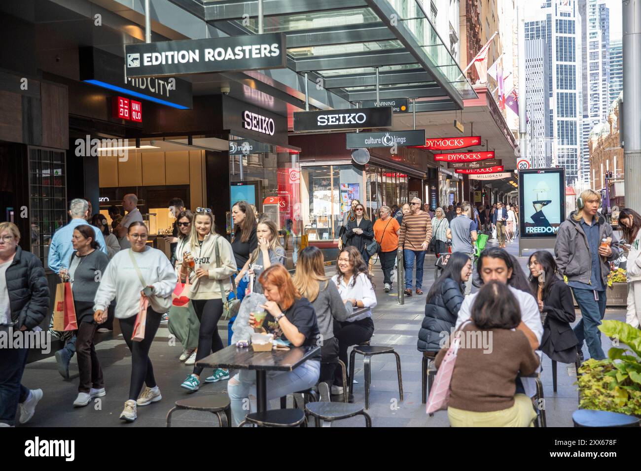 Boutiques et magasins du centre-ville de Sydney, les gens qui font du shopping et apprécient un café dans un café en trottoir sur George Street, magasins Seiko et Dymocks, Australie Banque D'Images
