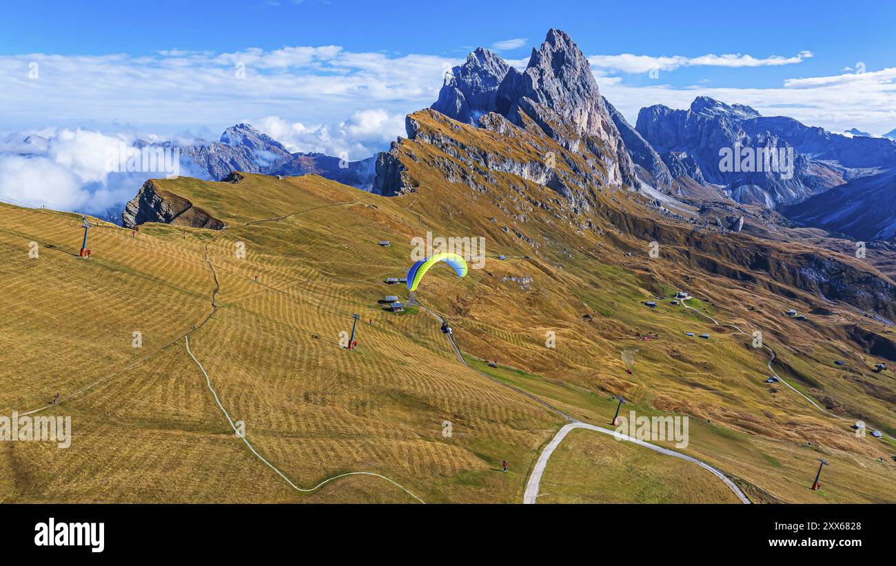 Parapente au-dessus des prairies alpines, en arrière-plan les sommets SAS Rigais et Furchetta du groupe Odle, drone shot, Val Gardena, Dolomites, autonome Banque D'Images