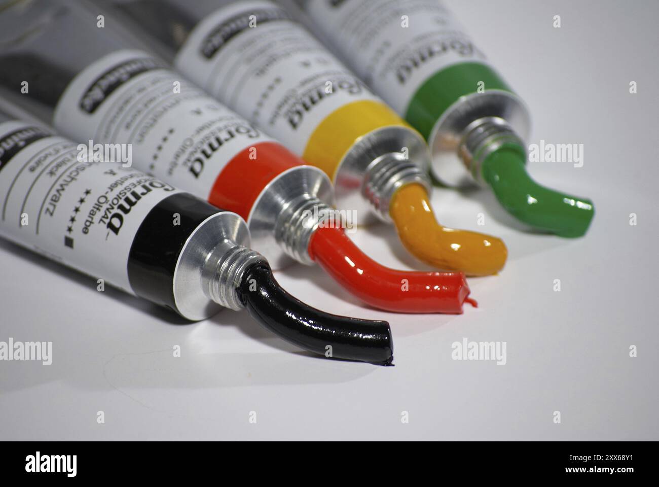 Quatre tubes de peinture, couleurs d'artiste, vert, jaune, rouge, noir Banque D'Images