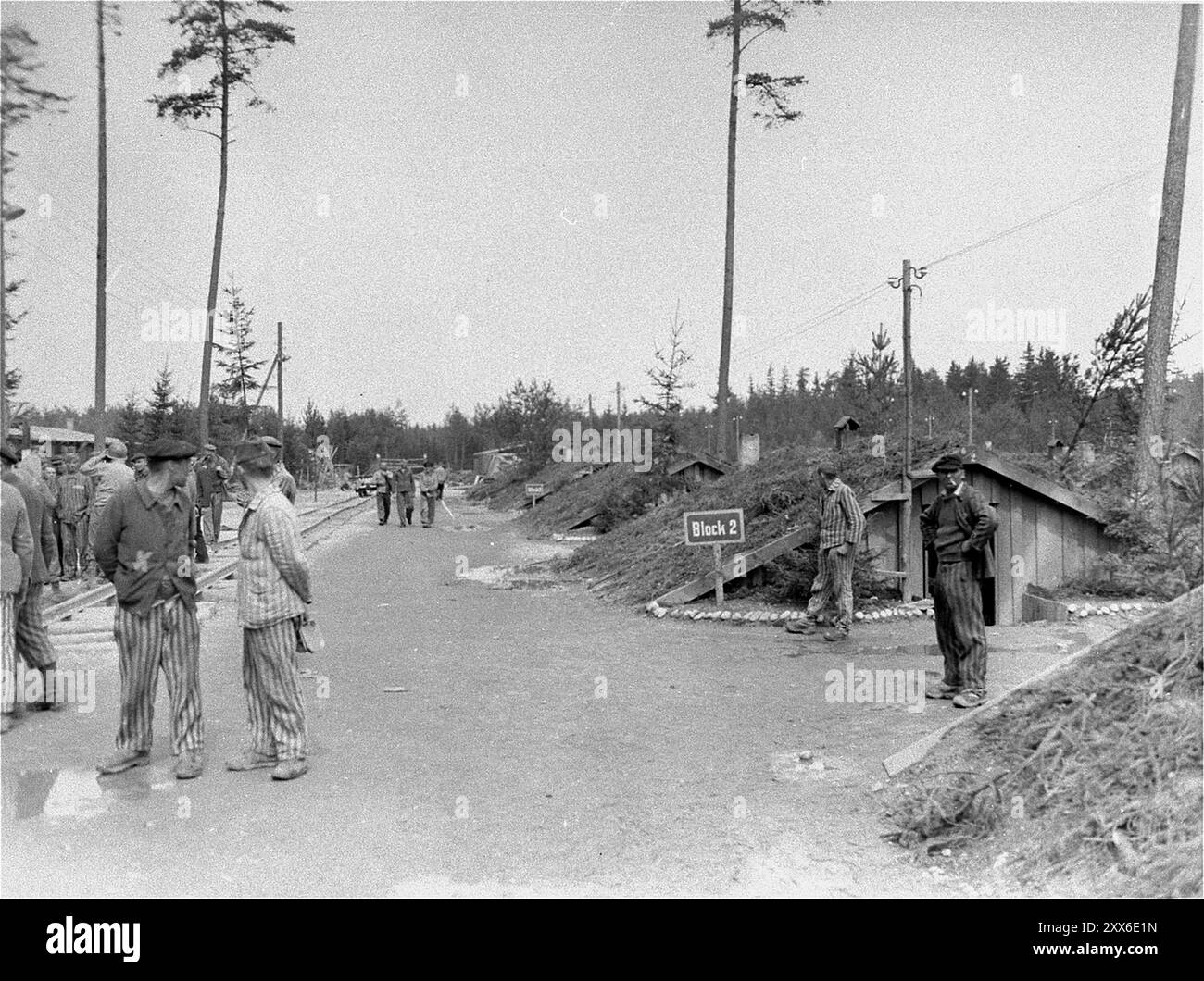 Les survivants du camp de concentration d'Ampfing se tiennent dans une rue du camp à l'extérieur de leur caserne. La photo est datée du 4 mai 1945. Ampfing était un sous-camp du complexe du camp de concentration de Dachau. Banque D'Images