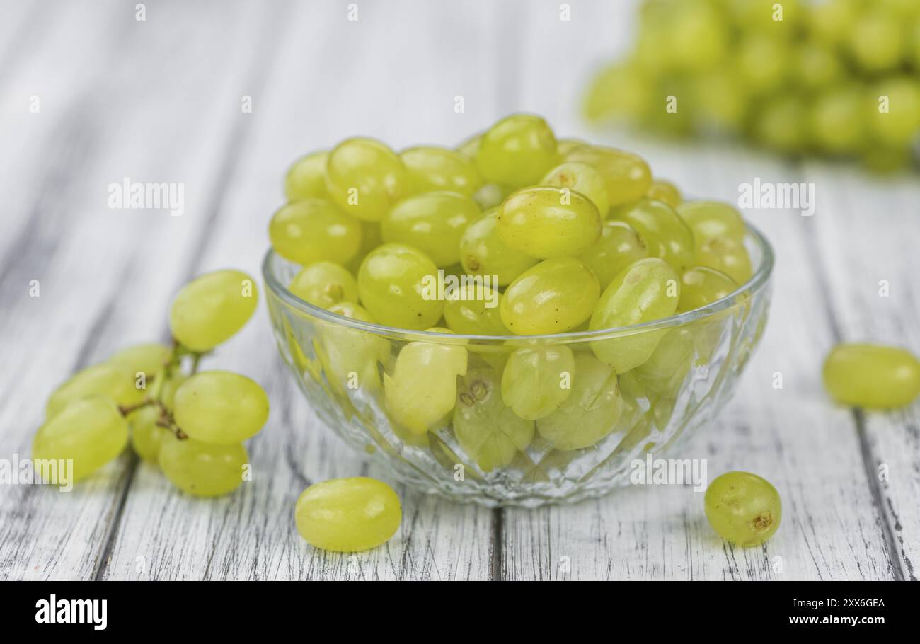 Portion de raisins blancs sains sur une vieille table en bois (mise au point sélective, gros plan) Banque D'Images