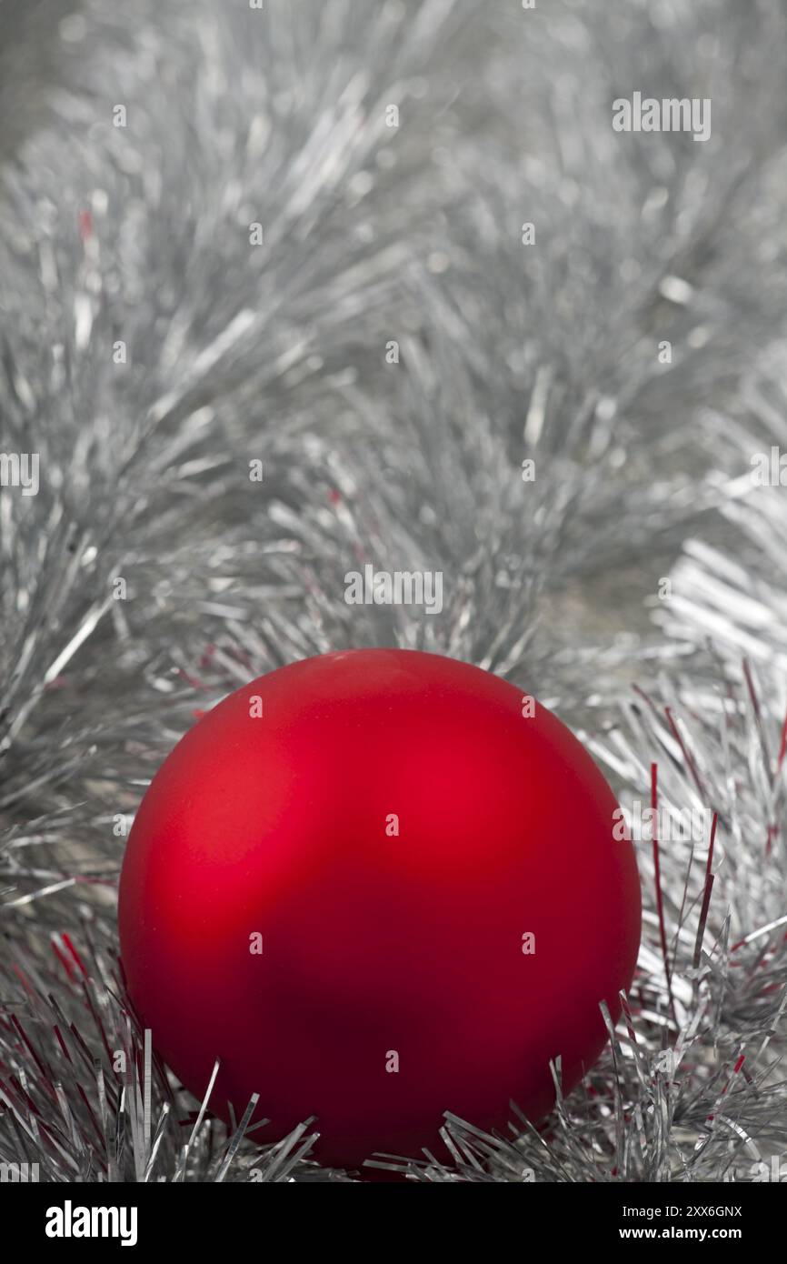 Boule de Noël rouge sur guirlandes argentées Banque D'Images