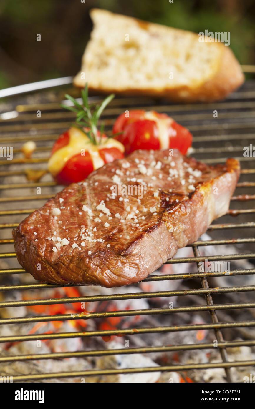 Steak sur le gril avec tomates Banque D'Images