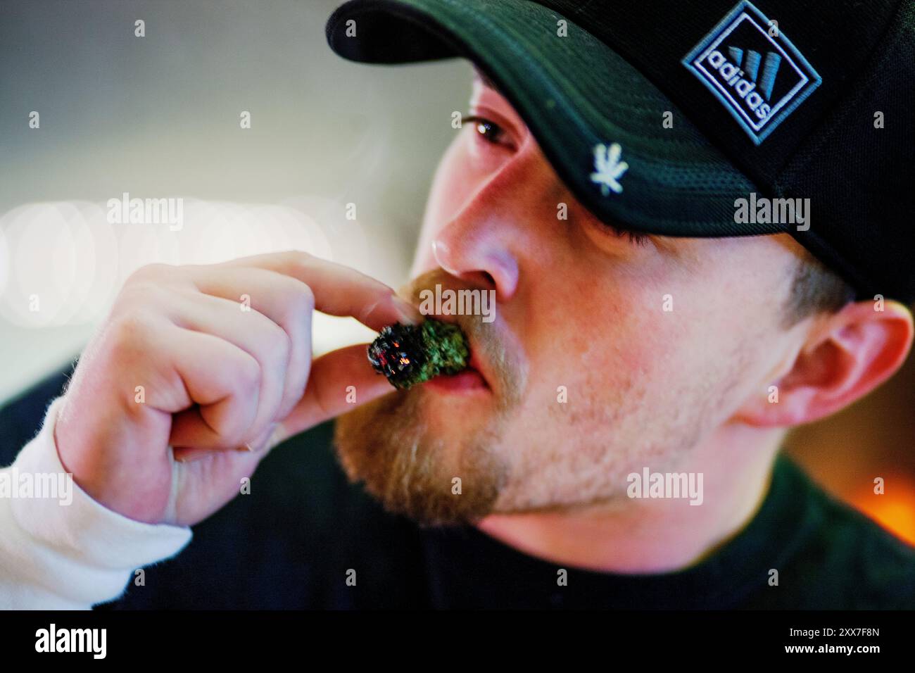 En av bud-tenderne i kafeen råflotter seg Med å røyke en av frøbelgene uten papir. Le célèbre cannabis Cafe de Portland propose toutes les saveurs de marihuana à ses membres. Banque D'Images En av bud-tenderne i kafeen råflotter seg Med å røyke en av frøbelgene uten papir. Le célèbre cannabis Cafe de Portland propose toutes les saveurs de marihuana à ses membres. Banque D'Images