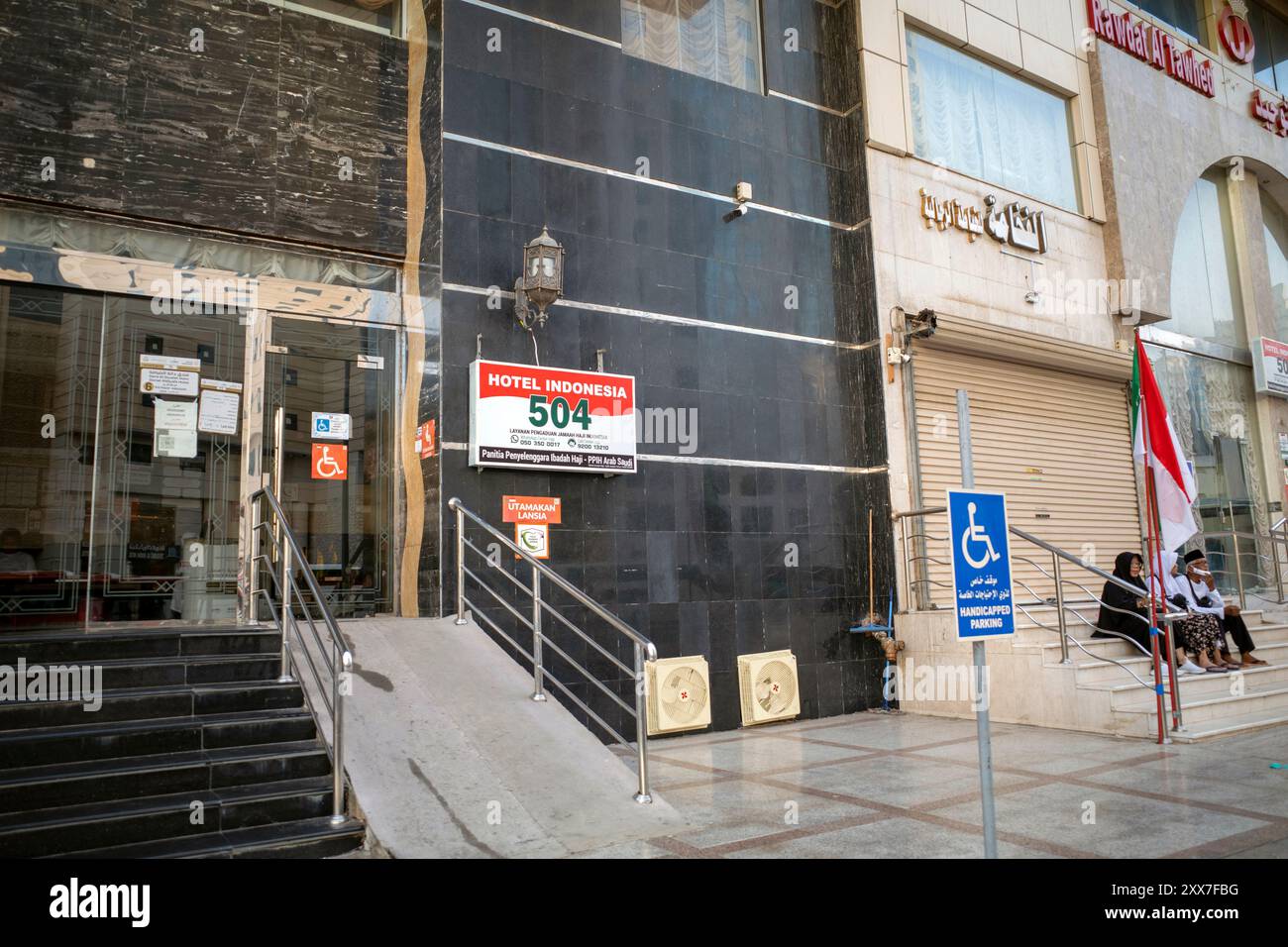 La Mecque, Arabie Saoudite - 3 juin 2024 : pèlerins du Hadj et de l'Oumrah venus d'Indonésie assis devant un hôtel à Makkah, Arabie Saoudite. Banque D'Images