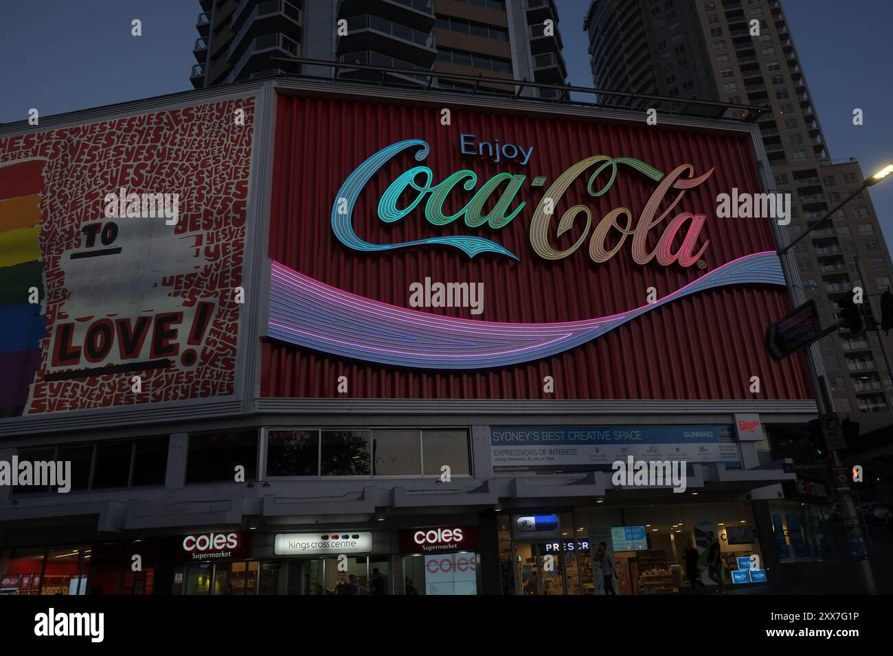 Le panneau Kings Cross Neon Coca illuminé aux couleurs de l’arc-en-ciel pendant mardi gras en solidarité avec la communauté LGBTQI+ Banque D'Images
