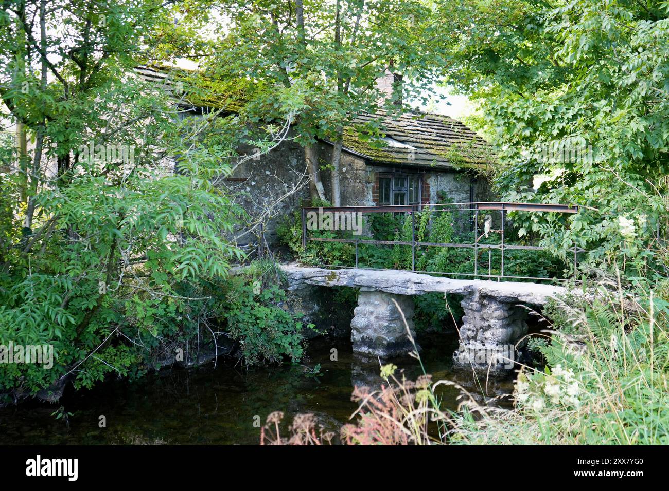 Pont de pierre rustique sur Malham Beck avec Malham Smithy derrière. Banque D'Images