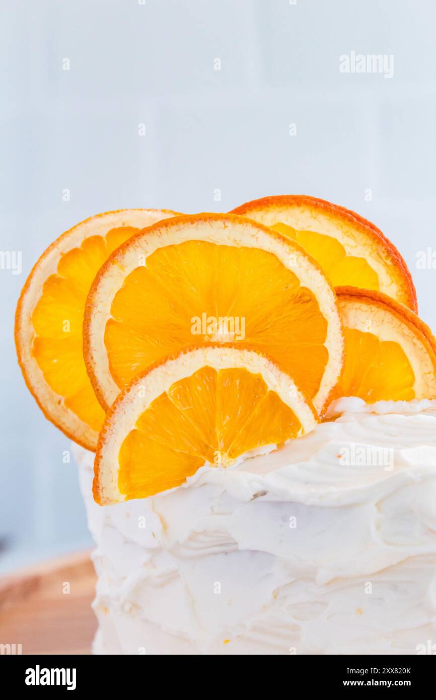 Tranches d'orange séchées sur un gâteau givré, vibrant et texturé Banque D'Images