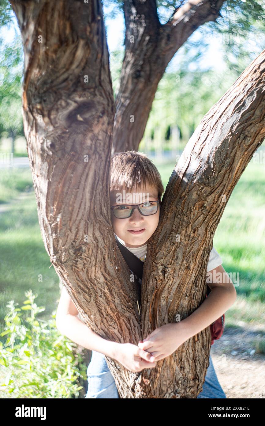Gentil garçon se reposant sur l'arbre Banque D'Images