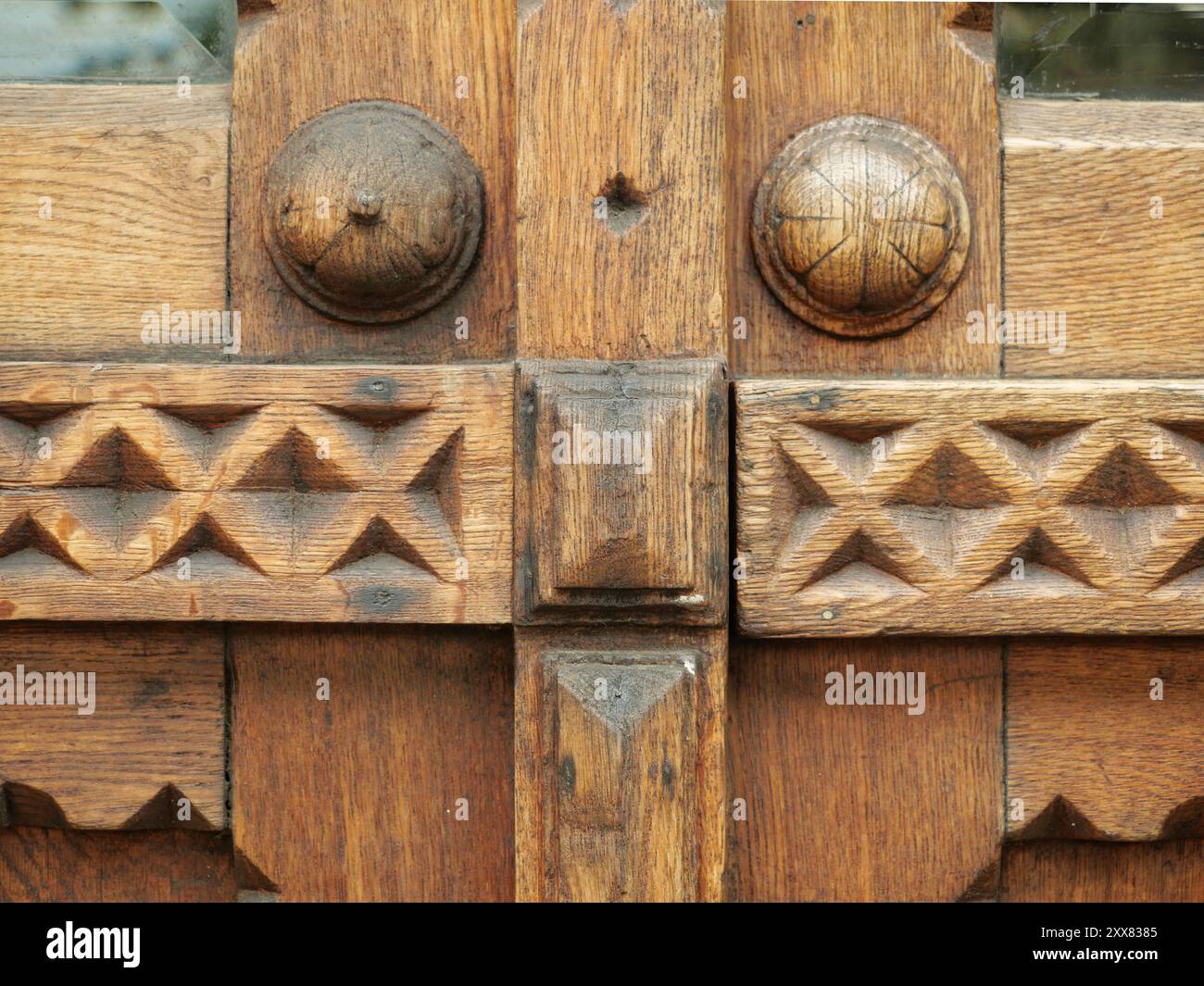 Une vue détaillée d'une porte en bois très ornée présente des sculptures complexes et un savoir-faire traditionnel, reflétant des boiseries historiques. Banque D'Images