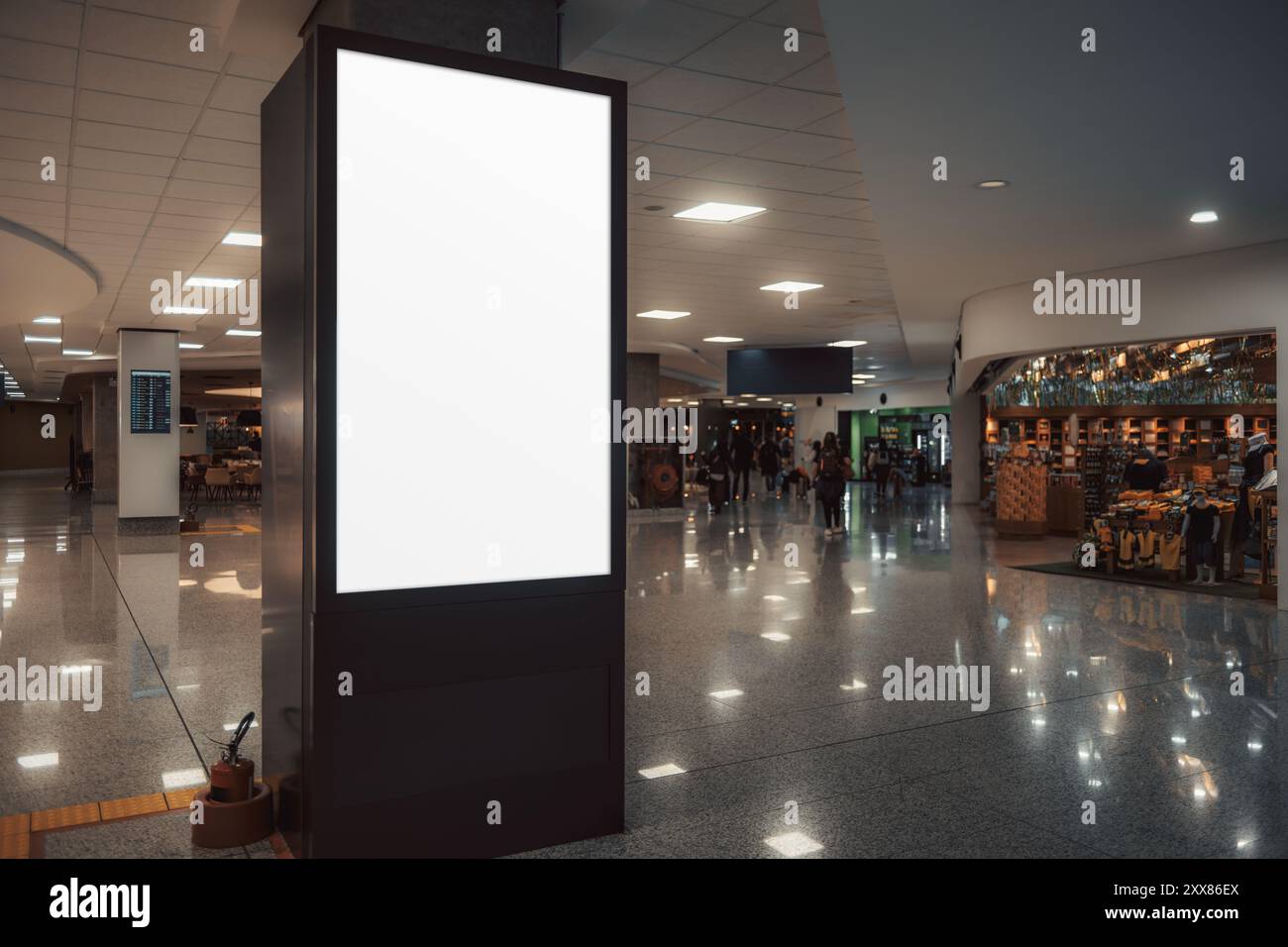 Une photo discrète d'une maquette de panneau d'affichage vide verticale se tient bien en vue au milieu d'un terminal d'aéroport animé ou d'un centre commercial, avec des magasins à l'intérieur Banque D'Images