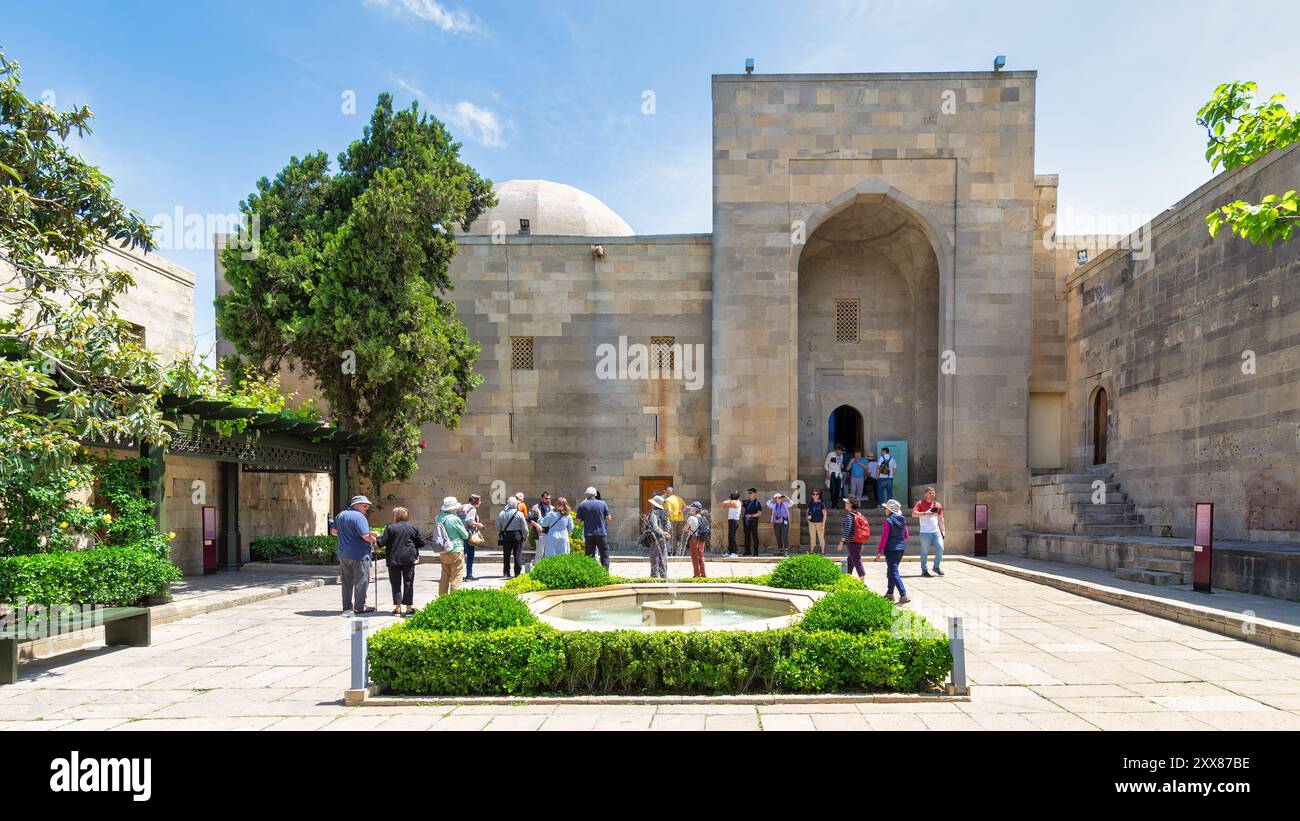 Bakou, Azerbaïdjan - 10 mai 2024 : les touristes se rassemblent dans la cour du Palais des Chirvanshahs, admirant l'architecture et la riche histoire Banque D'Images