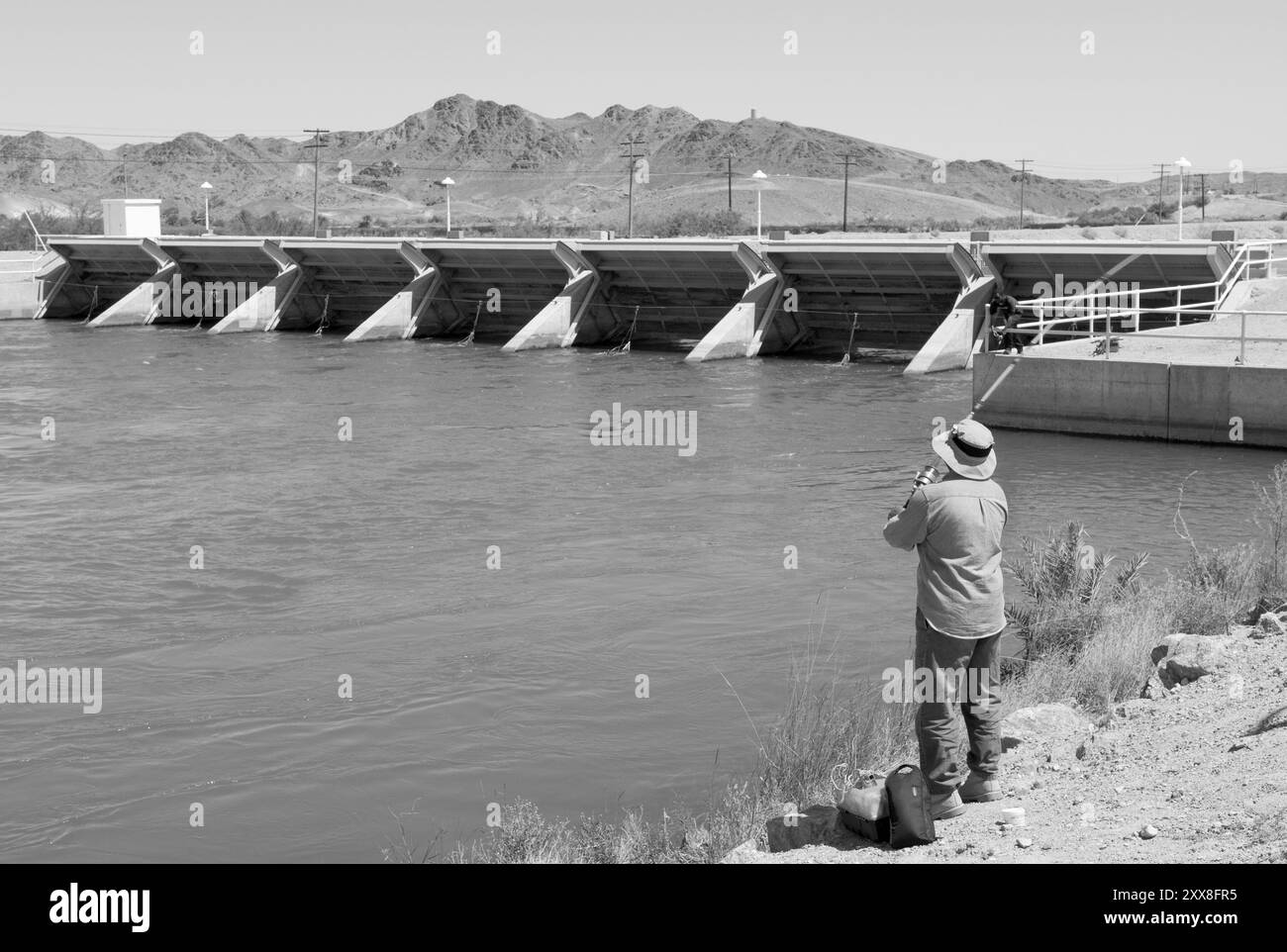 Homme caucasien pêchant à Imperial Dam à Yuma, Arizona, États-Unis. Le barrage, construit dans les années 1930, est un projet d’infrastructure clé dans la région. Banque D'Images