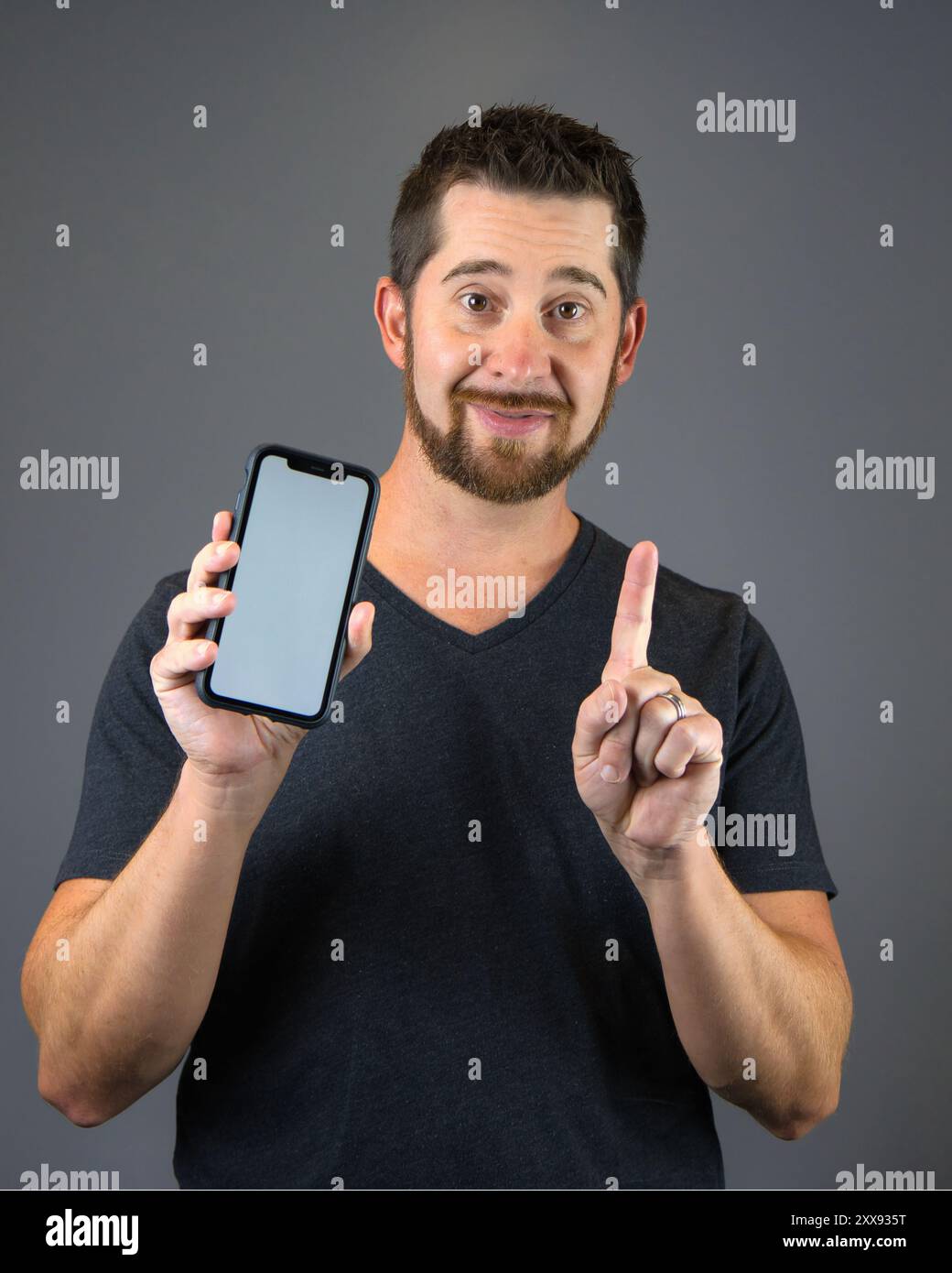 Autoportrait homme tenant smartphone avec écran vierge pour superposition de texte Banque D'Images