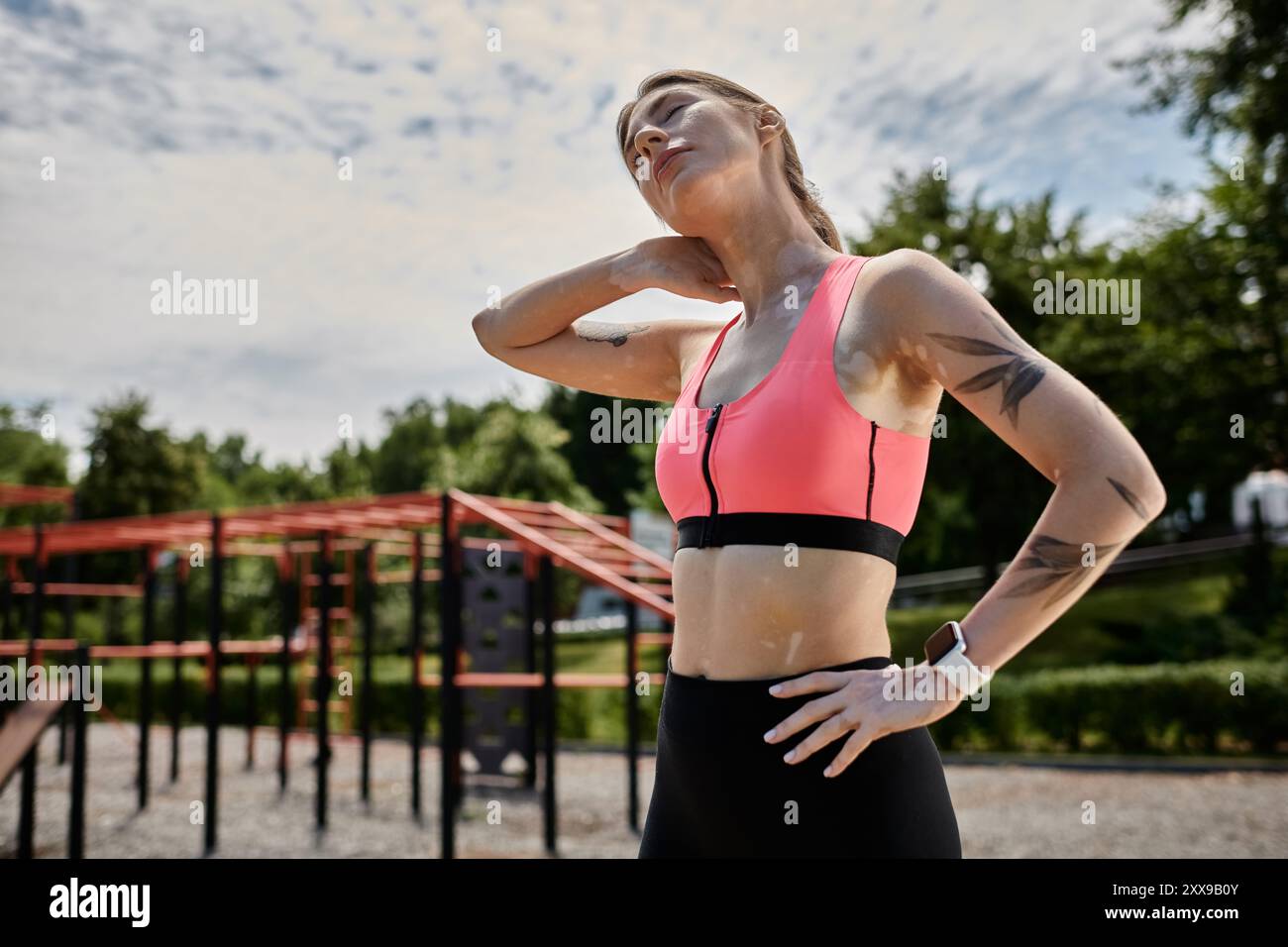 Une jeune femme atteinte de vitiligo étire son cou après avoir fait de l'exercice à l'extérieur. Banque D'Images