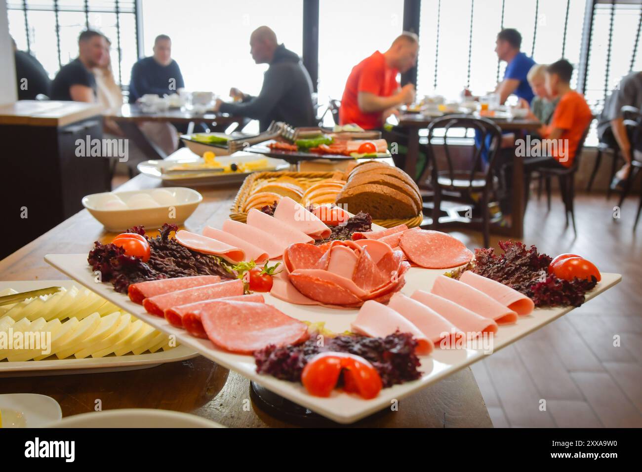 Groupe d'hommes caucasiens amis, la famille assis dans le restaurant de l'hôtel manger prendre le petit déjeuner avant de skier en vacances dans les montagnes enneigées Banque D'Images