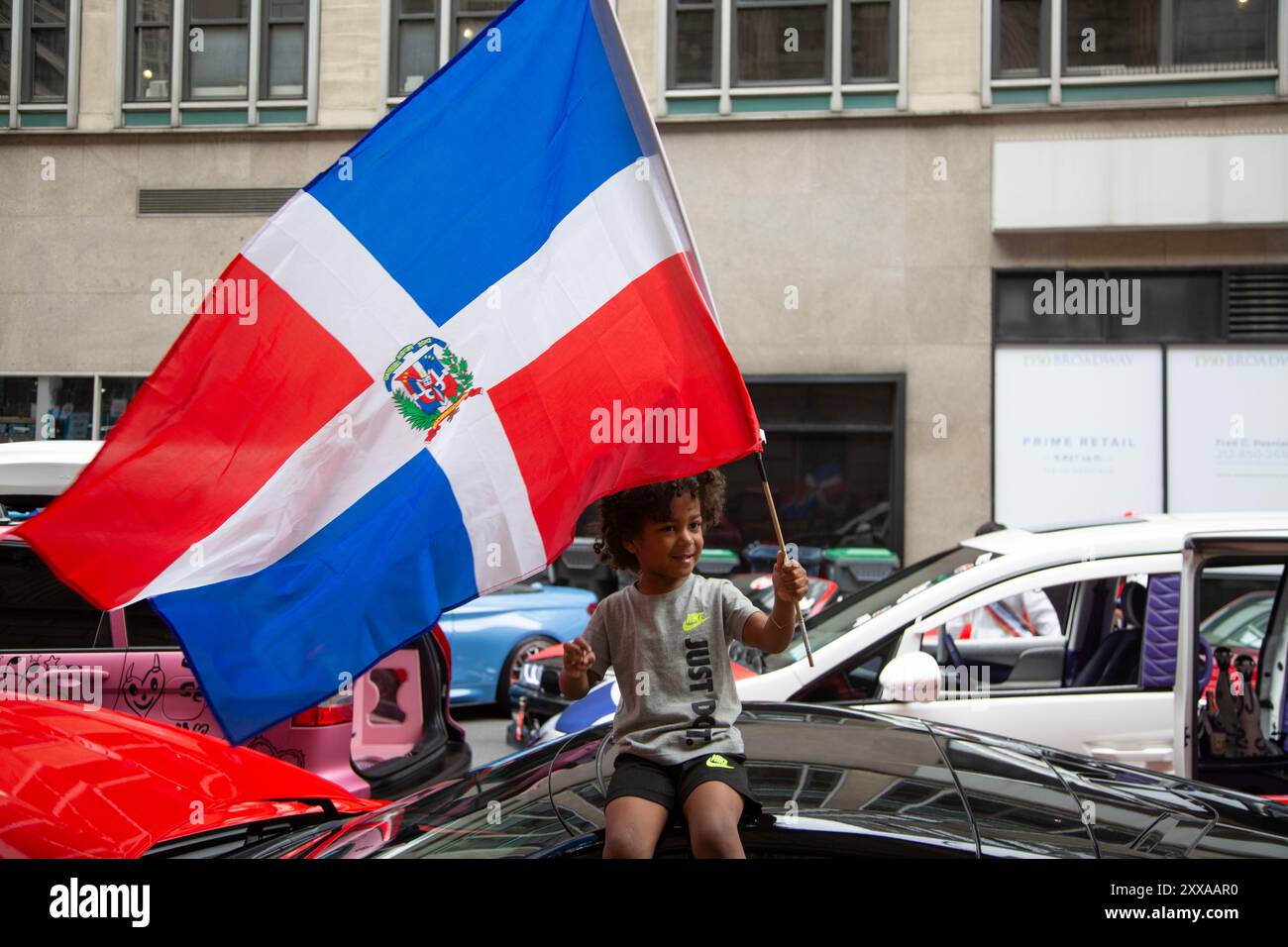 Défilé de la fête dominicaine : le jeune garçon hissait le drapeau dominicain le long de la 6ème Avenue à New York. Banque D'Images