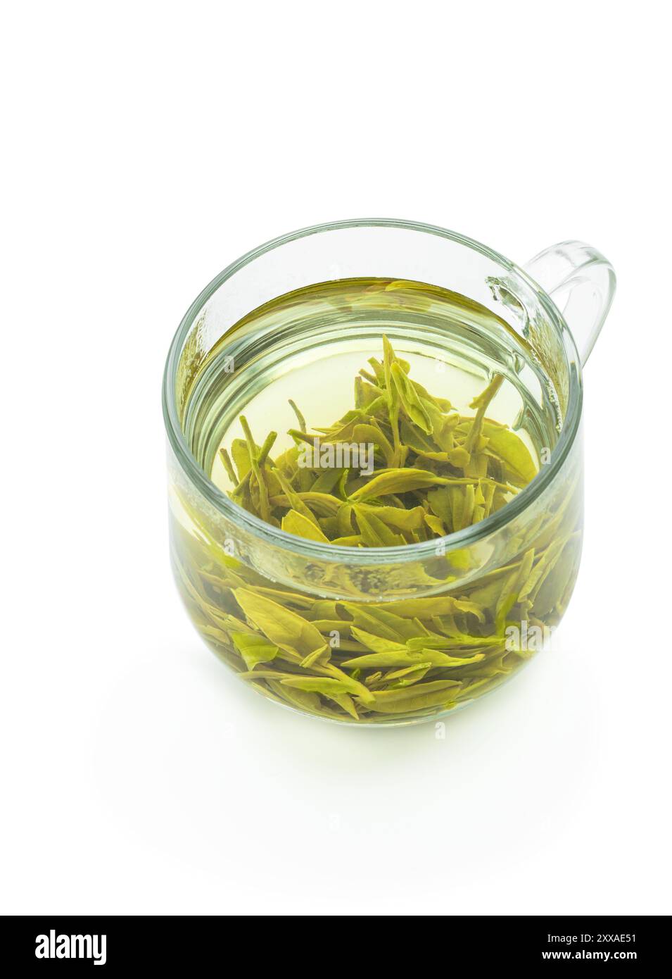 Thé Longjing dans une tasse en verre isolé sur fond blanc Banque D'Images