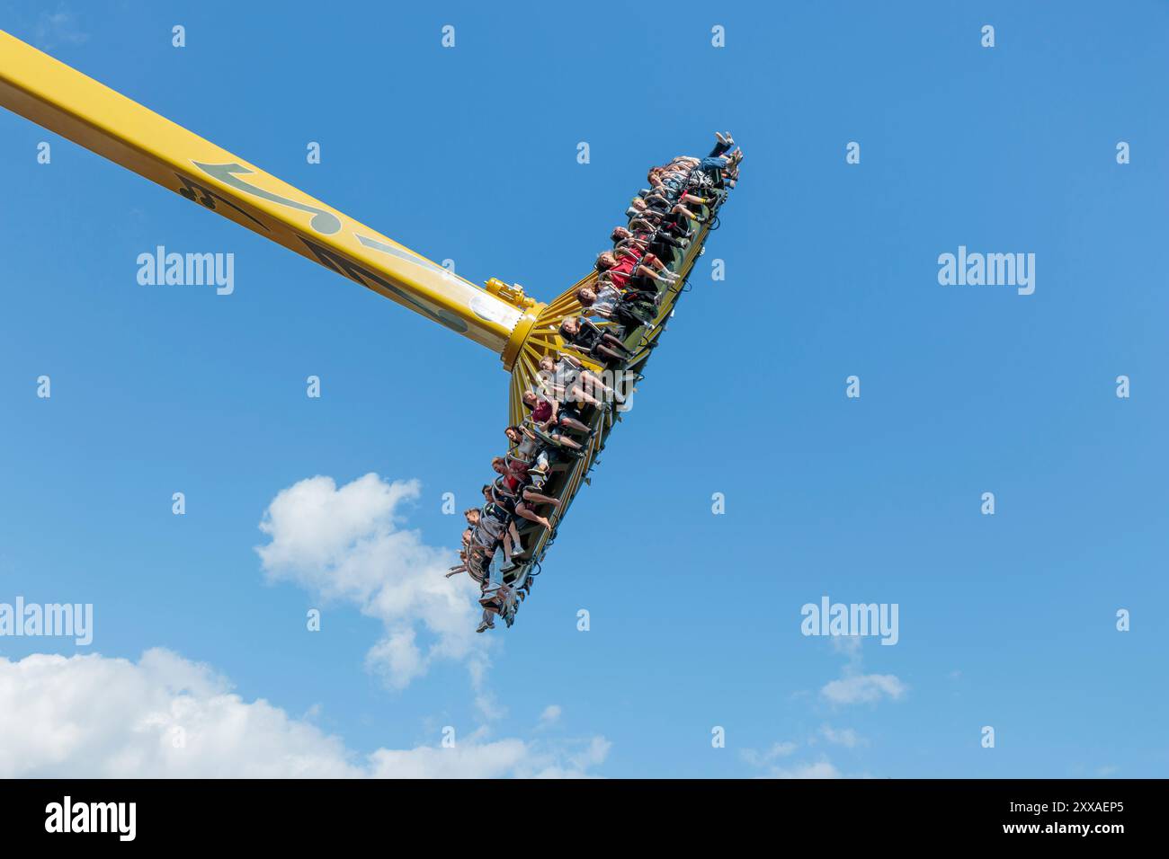 Helsinki, Finlande - 19 juillet 2024 : Parc d'attractions Linnanmaki, nouvelles montagnes russes Swingi en mouvement, ciel bleu sur fond, gens heureux Banque D'Images