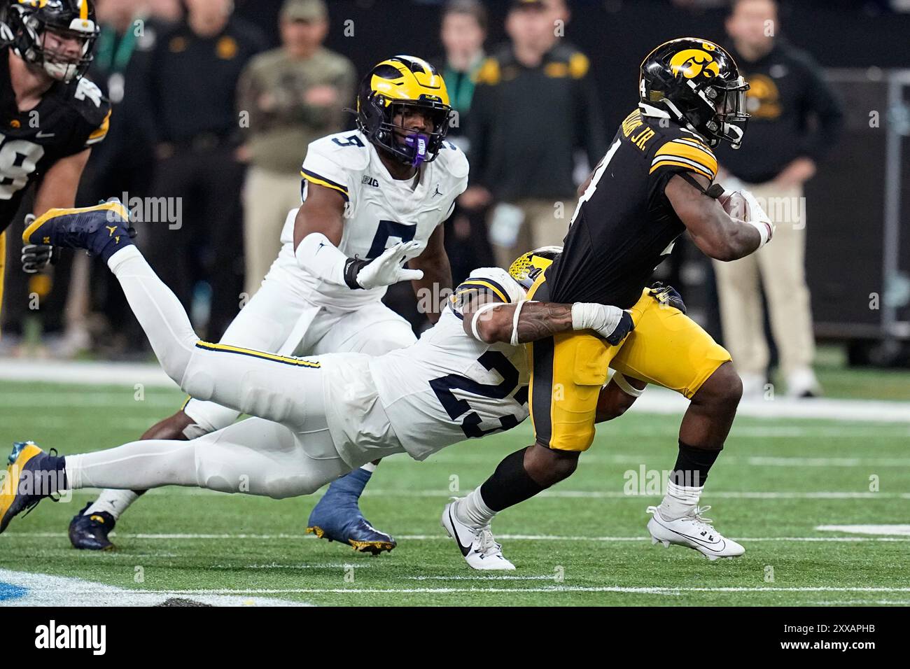 FILE - Iowa running back Leshon Williams (4) runs from Michigan linebacker Michael Barrett (23) and defensive end Josaiah Stewart (5) during the second half of the Big Ten championship NCAA college football game, Saturday, Dec. 2, 2023, in Indianapolis. (AP Photo/Darron Cummings, file) Banque D'Images