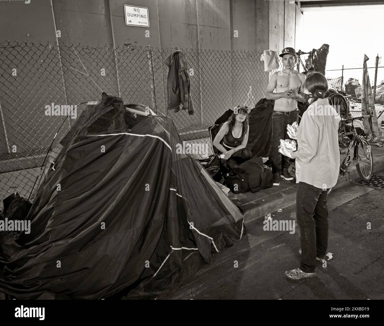 ARC-0017-BW...WASHINGTON - Penelope Protheroe d'Angel Resource Connection discute avec un couple de sans-abri dans un camp de sans-abri sous l'Interstate 5 en EV Banque D'Images