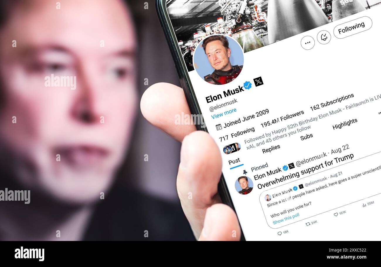 Poltava, Ukraine - 22 août 2024. Page de profil Twitter d'Elon Musk avec un smartphone à la main. En arrière-plan se trouve un portrait défocalisé d'Elon Banque D'Images