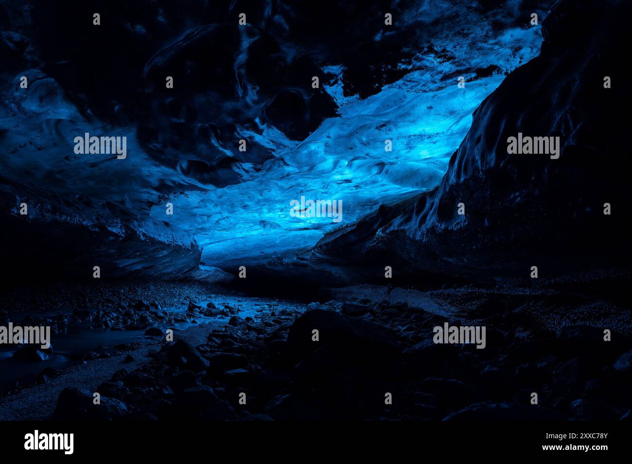 Une lueur bleue surnaturelle à l'intérieur d'une grotte de glace en Islande, capturant la beauté fascinante des formations glaciaires. Banque D'Images