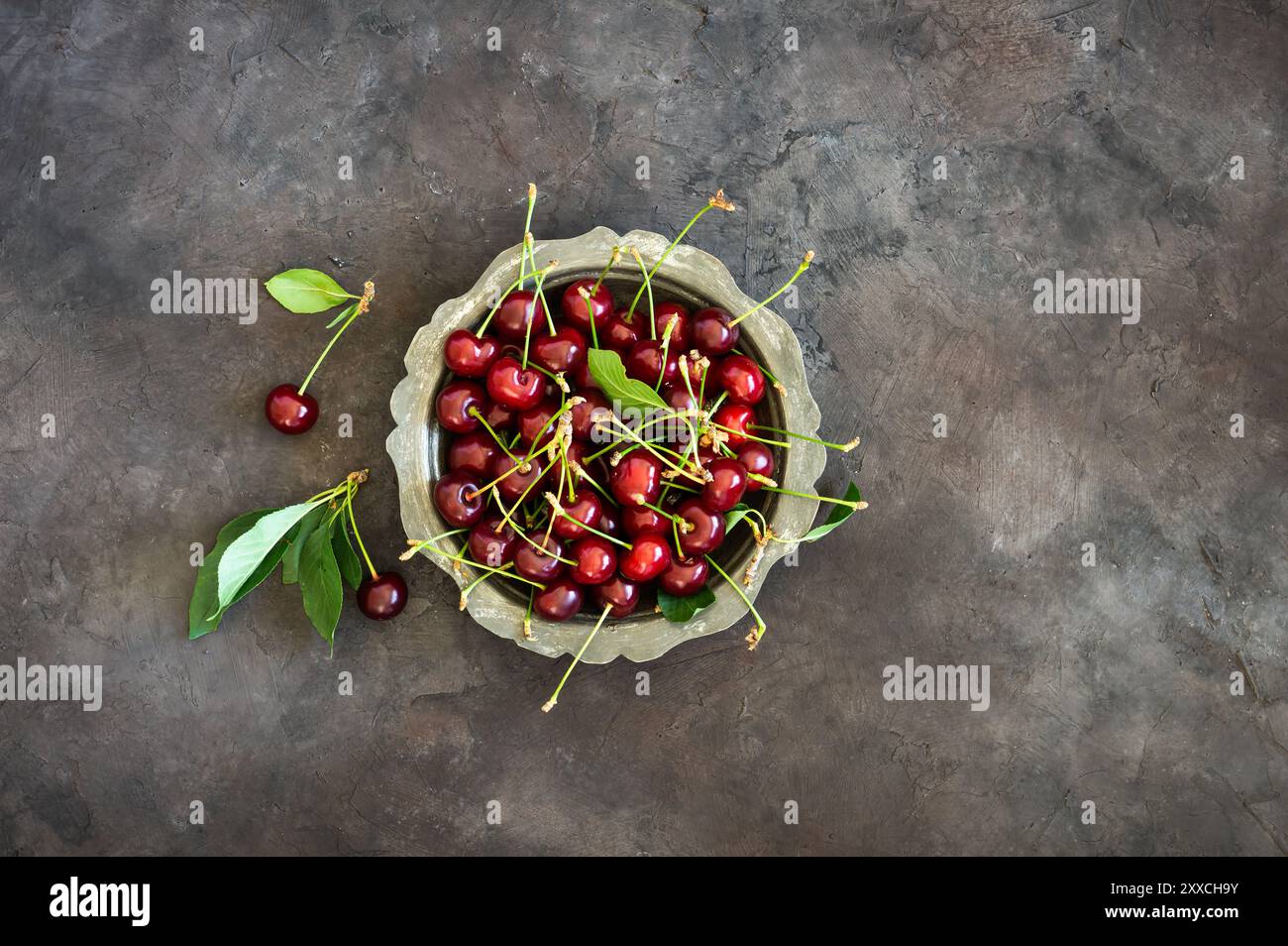 Fruits frais mûrs de cerise aigre dans un bol sur une table rustique, fruits rouges d'été Banque D'Images