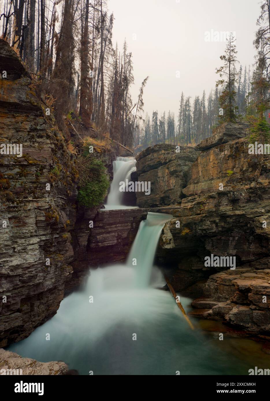 Chute d'eau dans le parc national des glaciers dans le Montana pendant un incendie d'été Banque D'Images