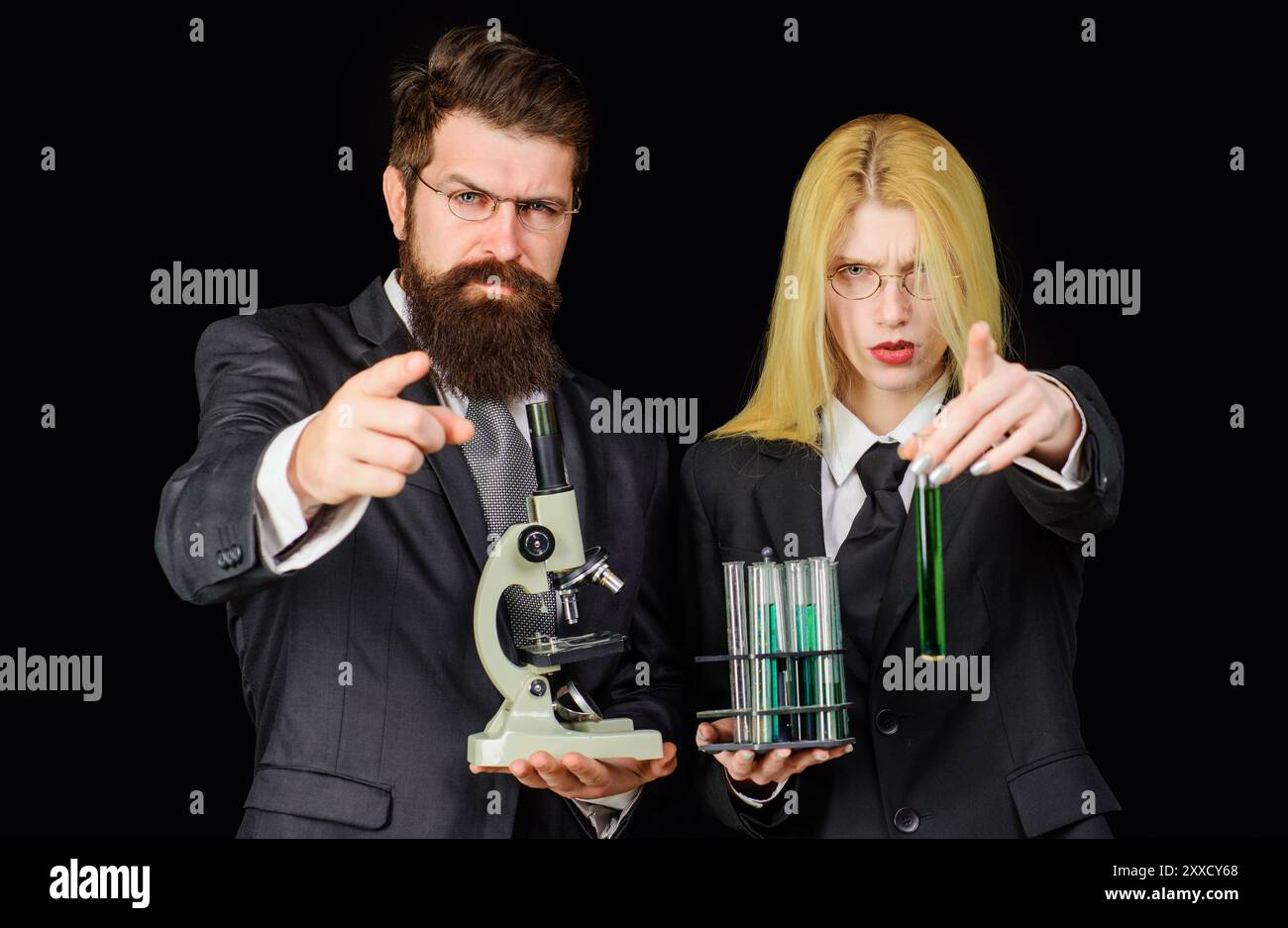 Expérience scientifique. Chercheur masculin et féminin avec des tubes à essai et microscope pointant vers vous. Science, chimie, technologie, biologie concept - Banque D'Images