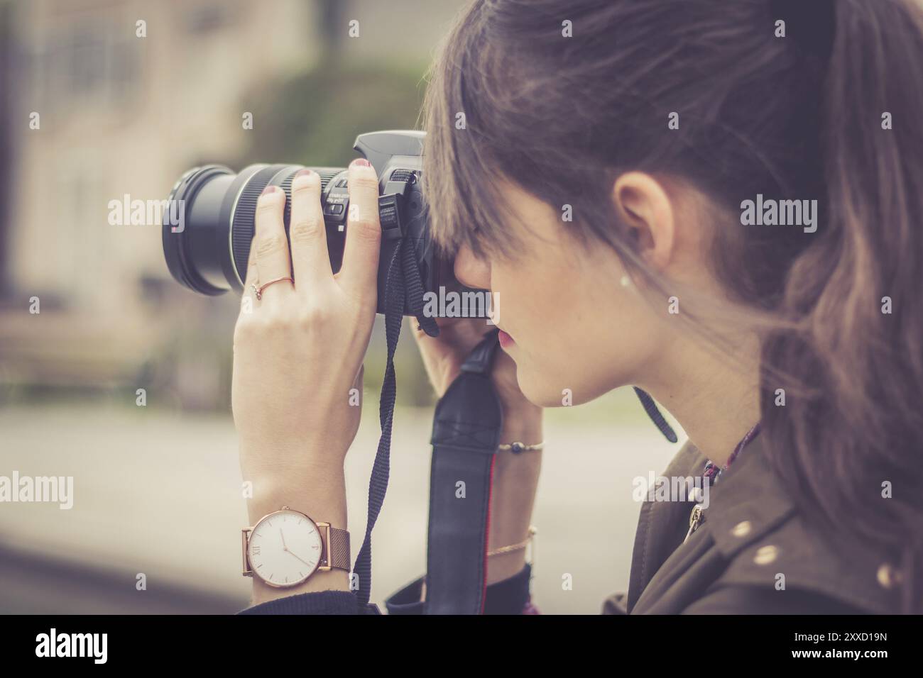 Jeune fille magnifique prend une photo avec son appareil photo. Vue de derrière Banque D'Images