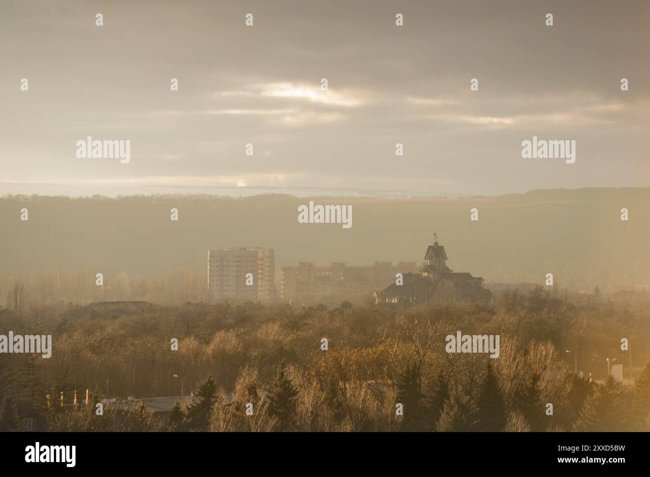Paysage d'automne de la ville de la partie parc de la ville dans la brume pré-fumée dans des tons chauds. Église catholique sur fond de gratte-ciel Banque D'Images