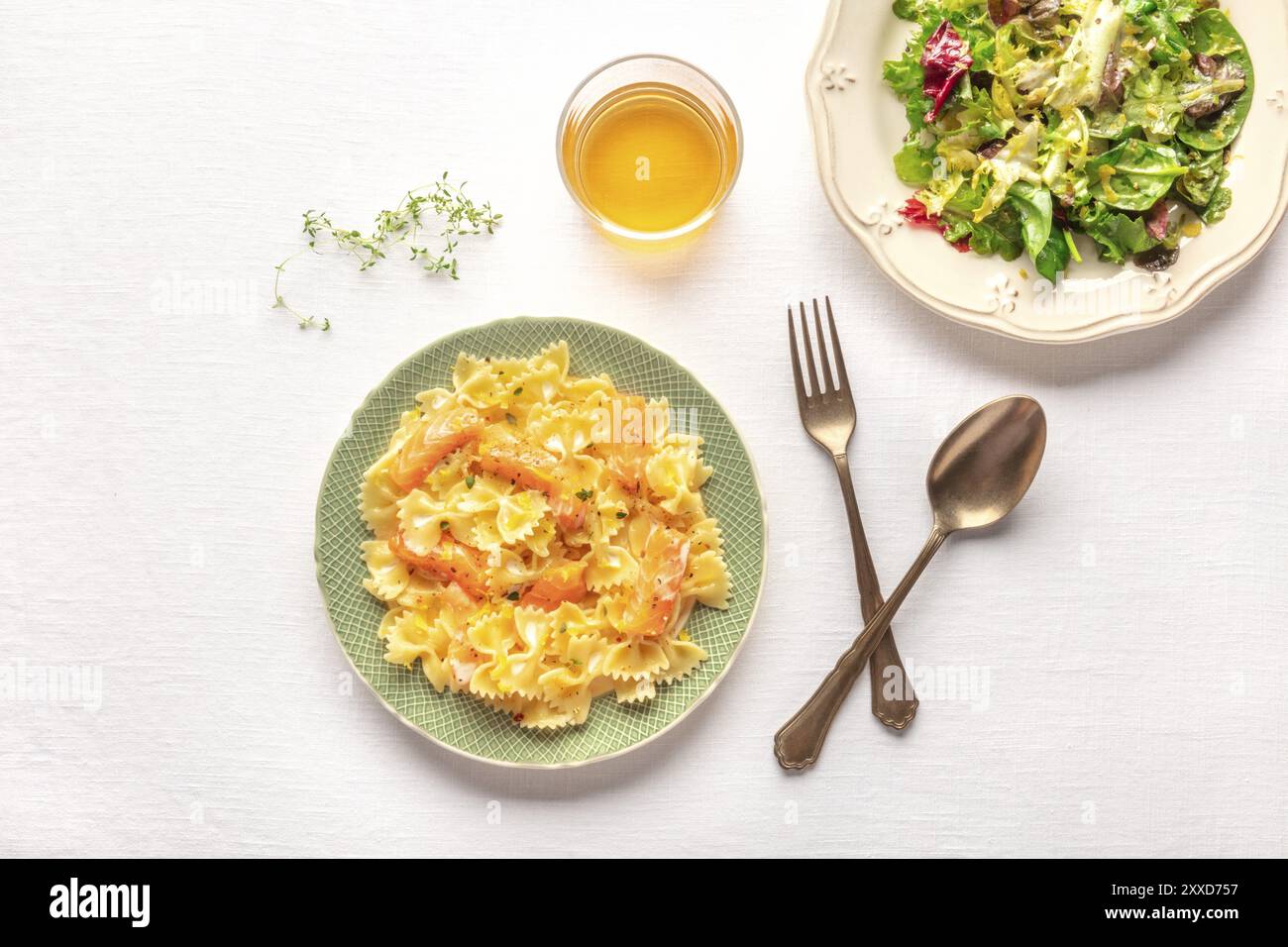 Les pâtes et le vin, repas italien. Farfalle au saumon fumé et à la crème, tourné par le haut avec un verre de vin, mesclun de salade, feuilles et copy space Banque D'Images