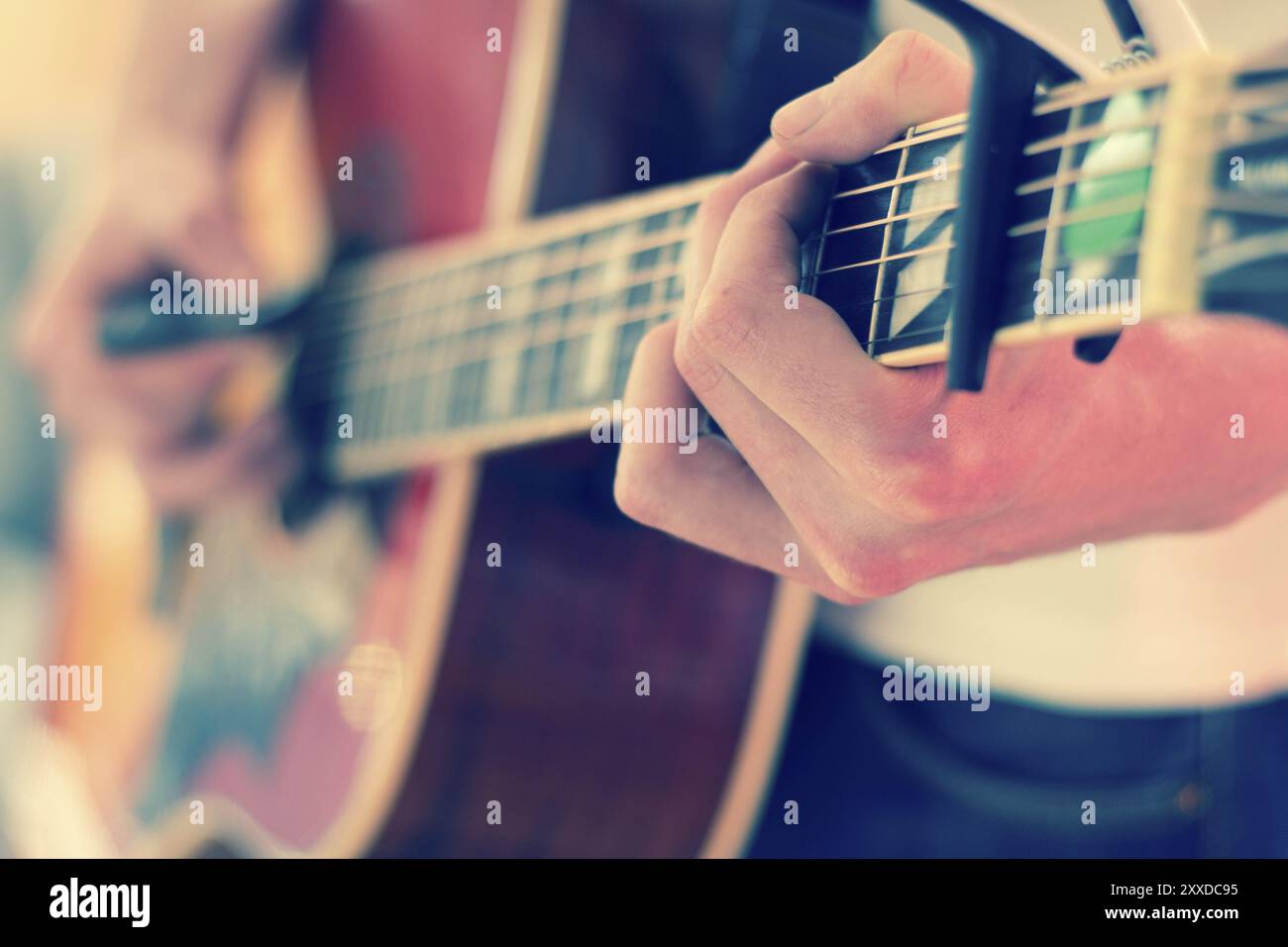 Jeune homme jouant un western sunburst guitare : découper, floue Banque D'Images