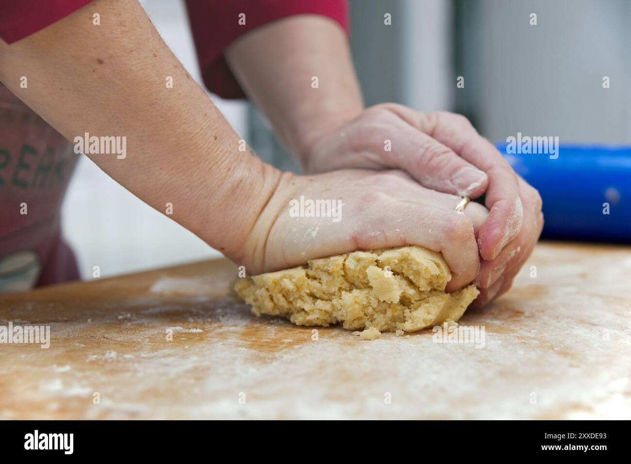 Les mains pétrissent la pâte à gâteau Banque D'Images