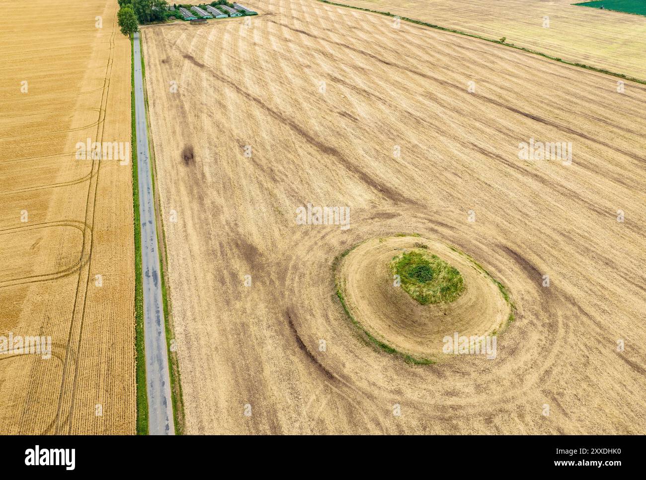 Une route passe devant un ancien monticule funéraire dans la campagne de Skamby sur l'île de Funen, au Danemark Banque D'Images