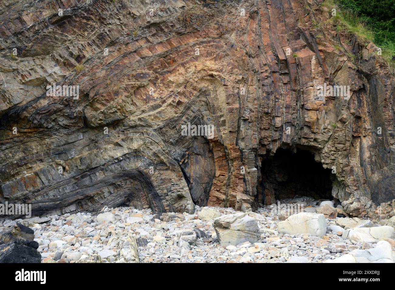 Pliage d'avions de literie à Monkstone point, Saundersfoot, pays de Galles. Une petite grotte marine (1,5 m de hauteur) a été formée par l'action des vagues à la base de la falaise. Banque D'Images