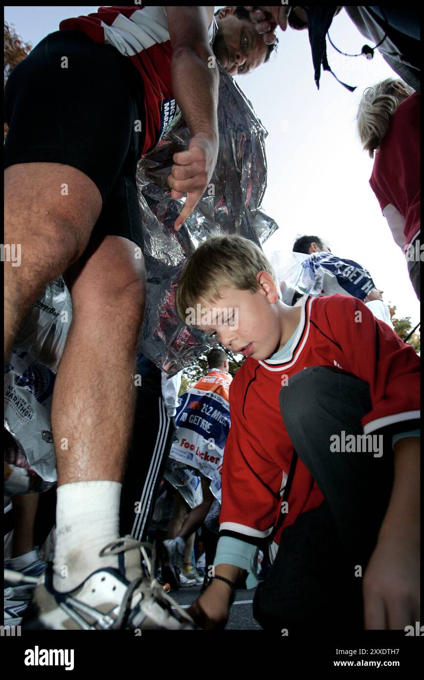 New York, NY, USA, 6 novembre 2005 : le Marathon ING de New York. Les coureurs danois qui transpirent lors d'un marathon exceptionnellement chaud. Johan Bay (9) donne à un papa douloureux de muscle (Bo) un coup de main aidant attachant ses baskets après la course. / Politiken Banque D'Images