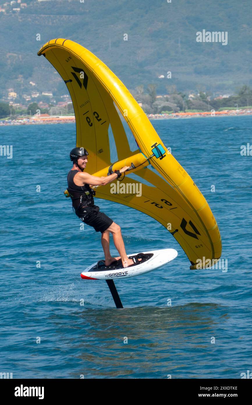 Fiumaretta di Ameglia, Italie - 22 août 2024 : L'homme pratique le fleuret dans la mer ligure. Wing foil est un sport nautique dynamique combinant le surf et le K. Banque D'Images