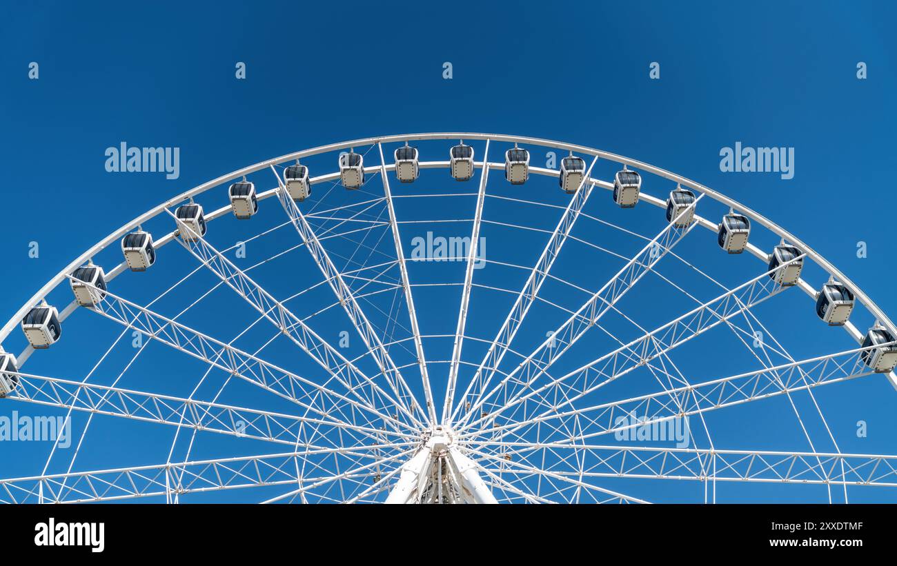 Détails des grandes roues, avec poutres métalliques et cabines passagers sur un ciel bleu clair Banque D'Images