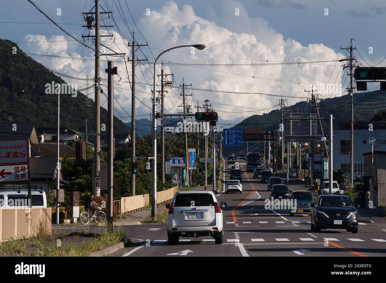 Une route près d'Uena dans la région rurale de Nagano avec un énorme nuage à l'horizon. Nagano, Japon. Banque D'Images