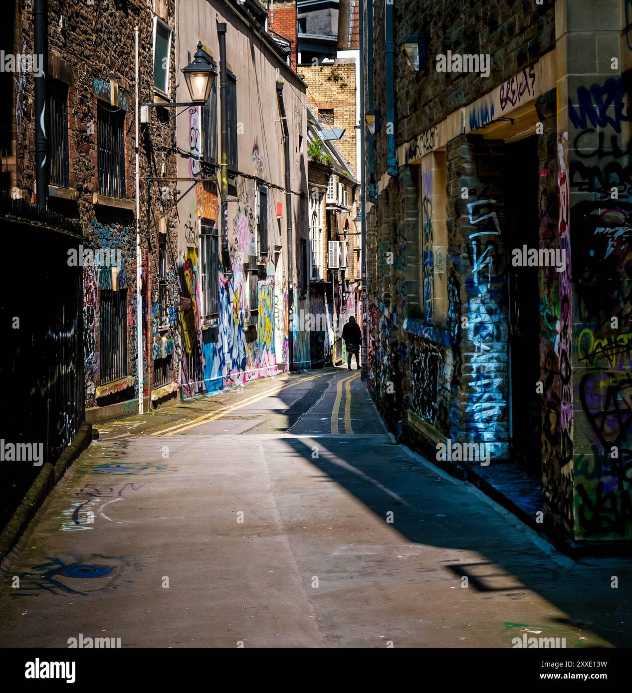 Personne marchant sur Lenard Lane Bristol, Street art, graffiti couverts murs Banque D'Images