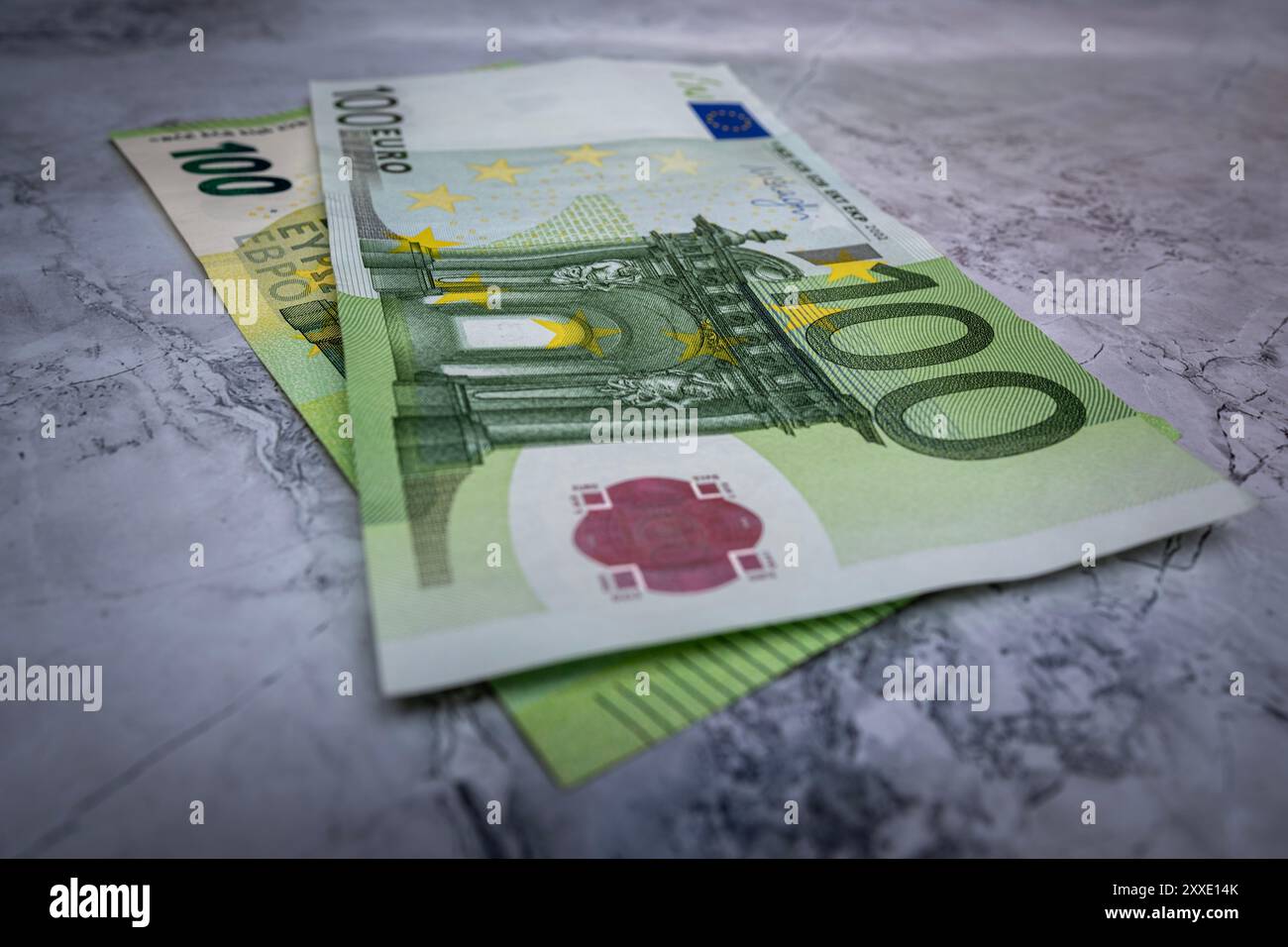 Gros plan de deux billets de 100 euros sur une surface en marbre, symbolisant la richesse, la finance et l’économie européenne Banque D'Images