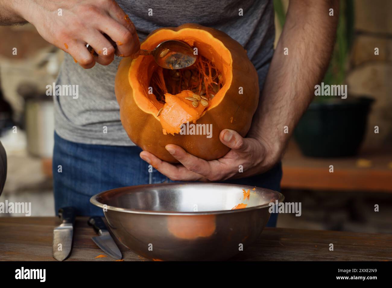 Homme sculptant une citrouille pour la préparation d'Halloween à la maison Banque D'Images